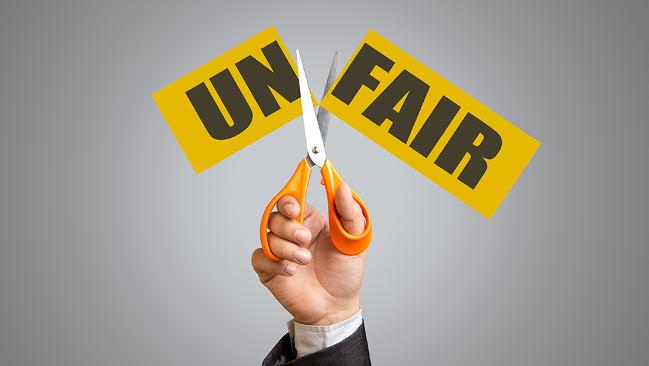 Schere zerschneidet Zettel mit dem Wort Unfair in Un und fair